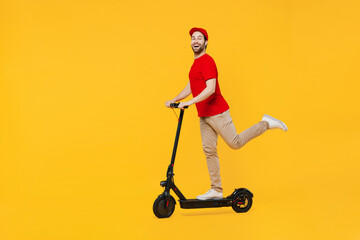 Full body side view delivery guy employee man in red cap T-shirt uniform workwear work as dealer courier ride electric kick scooter isolated on plain yellow background studio portrait Service concept