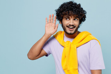 Young bearded Indian man 20s years old wear white t-shirt try to hear you overhear listening...