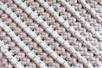 Fototapeta na wymiar Handmade macrame pattern close up. Macrame braiding and cotton threads. Female hobby. ECO friendly modern knitting DIY natural decoration concept in the interior.