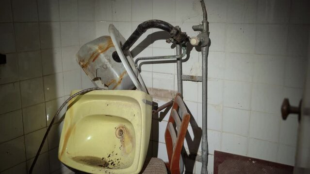 Washroom of a destroyed building, broken ceramic sink. POV with a flashlight in a ruined building. looters concept