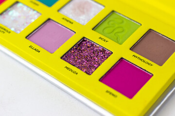 Eye shadow in a bright yellow case on a white background. Makeup Artist Cosmetics