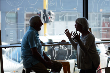 Catching up over coffee. Cropped shot of an affectionate senior couple in their local coffee shop.