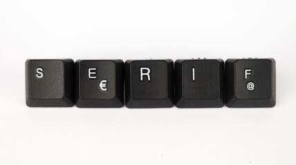 Serif text created with keyboard keys isolated on white background, white serif  font letters on black keyboard, top view