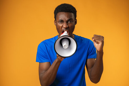 Young Black Man Shouting In Megaphone On Yellow Background