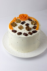 Carrot cake with cream cheese decorated with nuts and carrots
