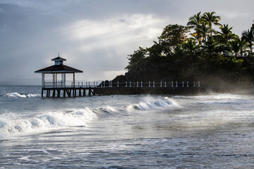 a pier in the sea and a gazebo in a landscape against the background of the sea and blue sky 