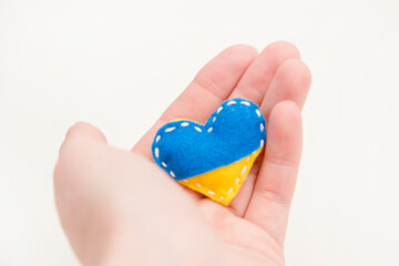 Ukraine flag theme. Heart shape pin badge made of blue and yellow stuffed felt. Topical issues of war. Freedom fighters. Support of nations, unity. Pray for peace. No war.