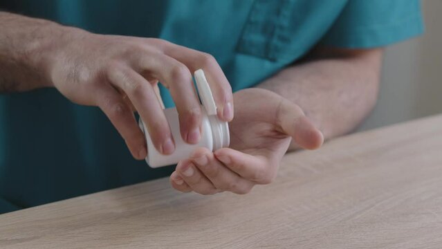 Close Up Body Part Of Unknown Man Doctor Patient Putting Painkiller Pills In Male Hand From Meds Bottle Taking Vitamins With Glass Water Doctor's Prescription Improve Human Immunity Treatment Concept