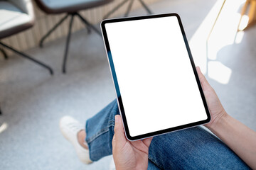 Mockup image of a woman holding digital tablet with blank white desktop screen in cafe