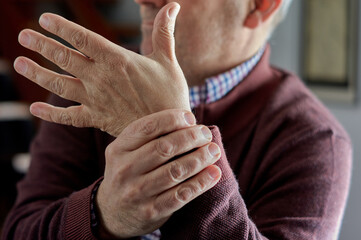 Mature man with wrist pain due to arthritis, rheumatism or osteoporosis.