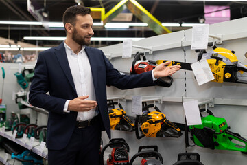 sales assistant in the store talks about gasoline chain saws