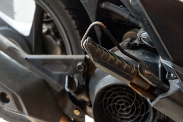 close up of motorcycle foot peg made of iron and black rubber