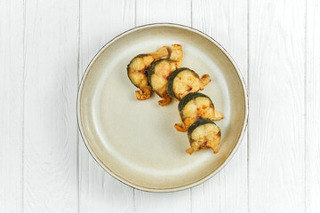 Fried mackerel in a plate on a white wooden background