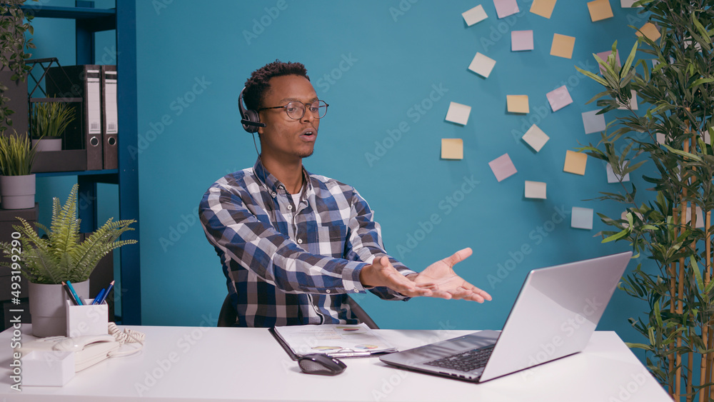 Poster call center operator having argument with client on helpline using headset with microphone and lapto