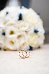 wedding gold rings on the background of a bouquet