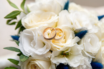 wedding gold rings on the background of a bouquet