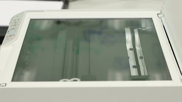 Hand holding a paper, inserting a scanner concept scanner for office automation 