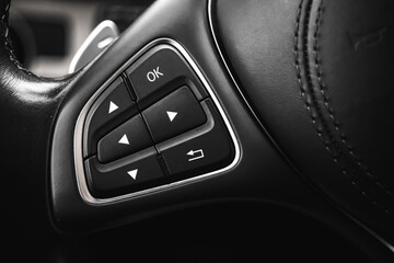 Steering wheel controls button inside luxury car with leather interior. Modern vehicle background photo