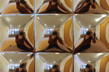 Virtual images reflected in diverging mirror, spherical mirror creating optical illusion of...