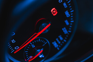 Glowing car speedometer close-up view background. Luxury dashboard with round speedometer inside...