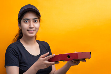 Delivery woman carrying Pizza box against Yellow background