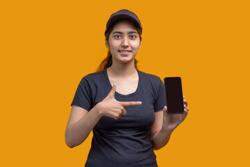 A young woman pointing towards the Smart phone in her hand