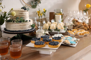 Beautiful cake and other treats on table in room. Baby shower party