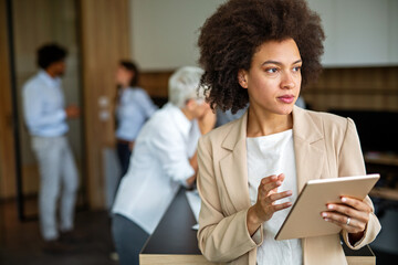 Obraz premium Happy business woman manager holding tablet and working in modern office