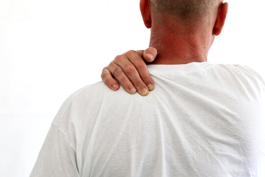 Middle Aged Man Has Shoulder Pain Stress Muscle Around The Neck. Man With White Shirt Holding Shoulder Got Injured From Sport, Isolated On White Background With Copy Space For Text.