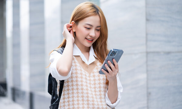 Young Asian woman using smartphone on street