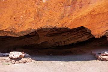 Cave in red eroded mountains. Nature scenic background. Sandstone erosion process due to wind and rains. Dzhuuku gorge.
