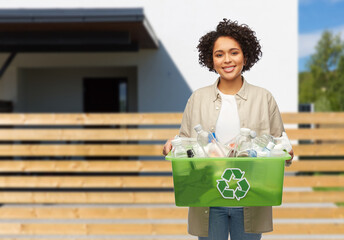waste sorting and sustainability concept - smiling young african american woman holding plastic box...