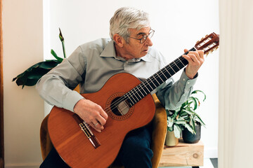 elderly gentleman playing classical guitar