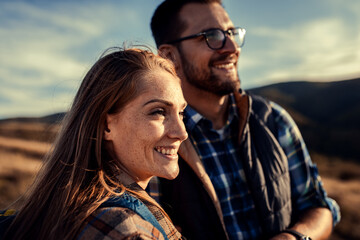 Couple with backpacks hiking together in nature.