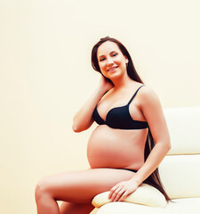 Obraz premium young brunette woman at home in chair pregnant, lifestyle people concept