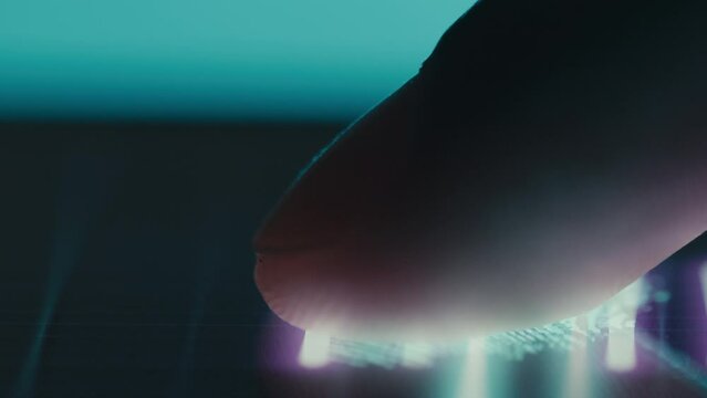 A man's finger is scanned by a digital security device