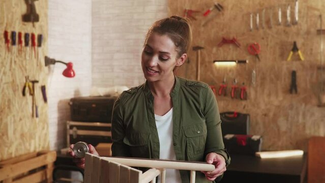 Woman carpenter measuring a wooden chair