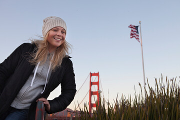 View of a young girl in black coat near golden gate in San francisco
