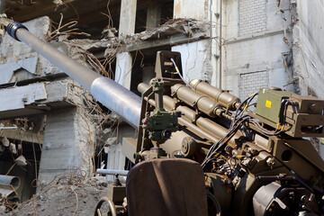 Artelleriegeschütz vor zerbombtem Wohnhaus