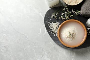 Fototapeta na wymiar Flat lay composition with soaked rice and grains on light grey marble table. Space for text