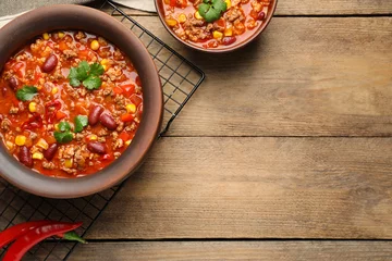 Gardinen Chilischoten Tasty chili con carne on wooden table, flat lay. Space for text  © New Africa