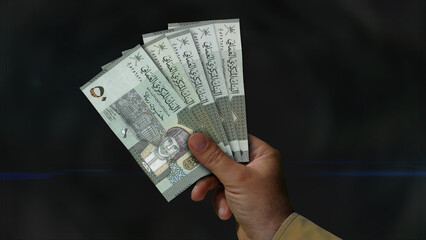 Oman Rial growing pile of money in hand concept 3d illustration