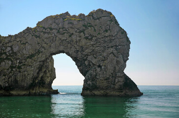 The famous rock formation known as Durdle Door from the beach, on a lovely sunny and calm day:...