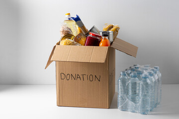 charity, support and concept - close up of food in donation box and water
