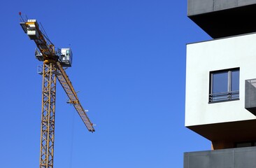 Budowa apartamentowca -  fragment elewacji z dźwigiem budowlanym