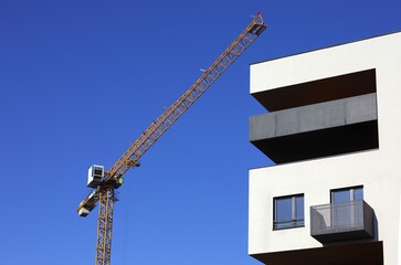 Budowa apartamentowca -  fragment elewacji z dźwigiem budowlanym