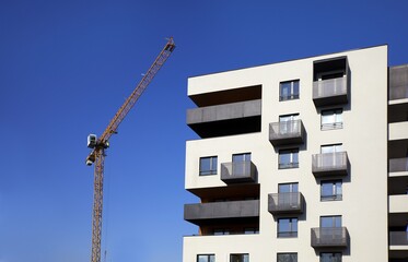 Budowa apartamentowca -  fragment elewacji z dźwigiem budowlanym © arteffect.pl