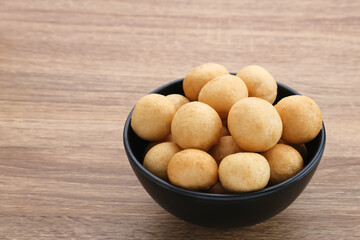 Kerupuk Tenggiri, Indonesian crackers made from mackerel fish. Served in black bowl on wooden background.
