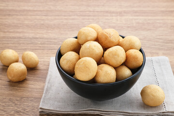 Kerupuk Tenggiri, Indonesian crackers made from mackerel fish. Served in black bowl on wooden background.
