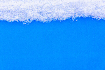 White snow on a blue background (copy space).